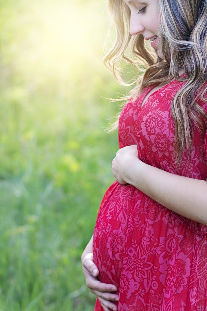 pregnant-woman-rests-after-prenatal-massage a pregnant woman in a red dress after a prenatal massage